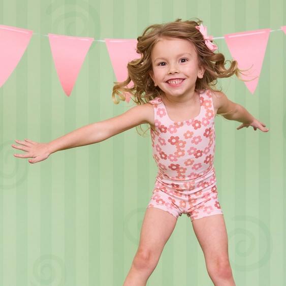 Little girl wearing pink floral athletic one piece.