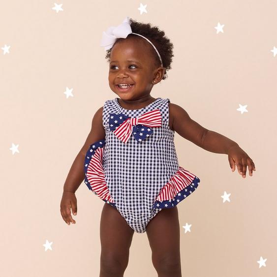 Little girl wearing red white and blue one piece.