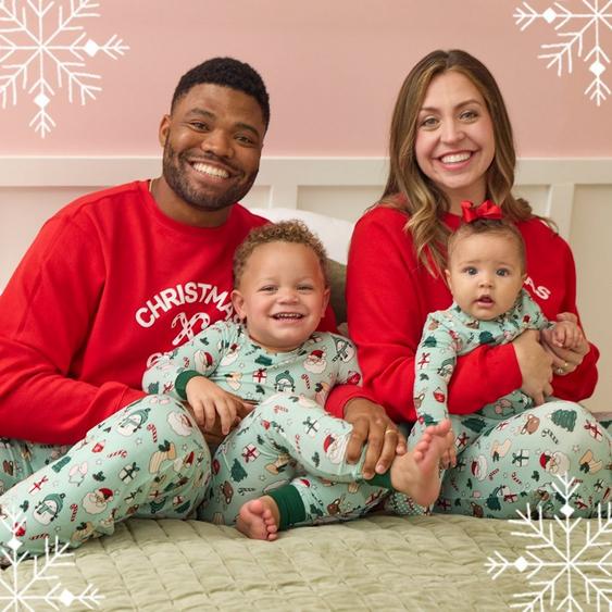 Family of four wearing matching Christmas green and red pajamas.