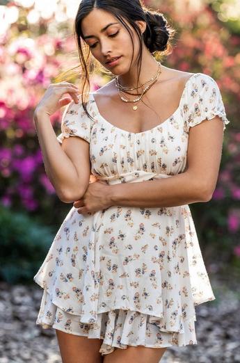 Woman wearing a floral romper with short sleeves and a crossover waistband