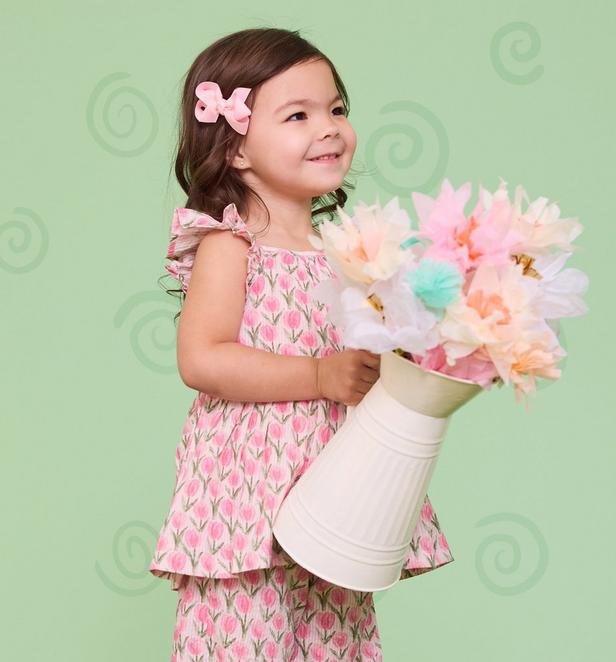 Little girl wearing matching pink floral top and pants.