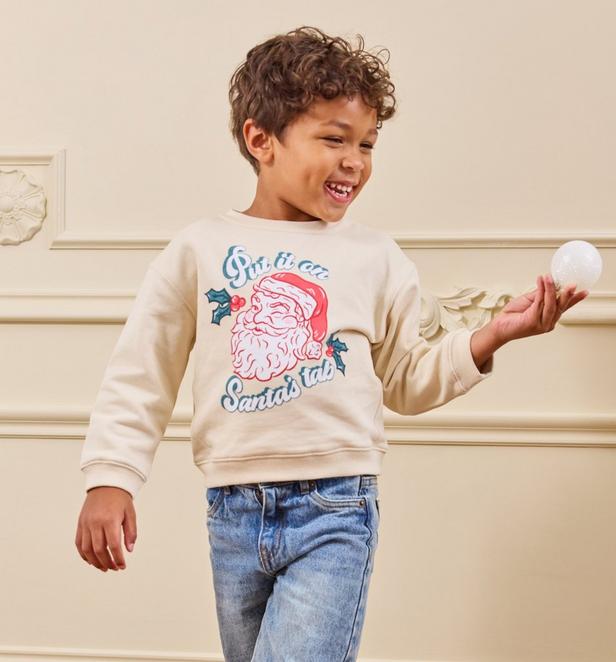 little boy wearing a santa clause pullover