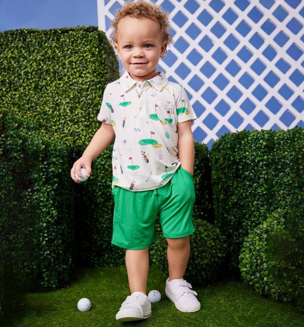 Little boy wearing a golf polo and green shorts