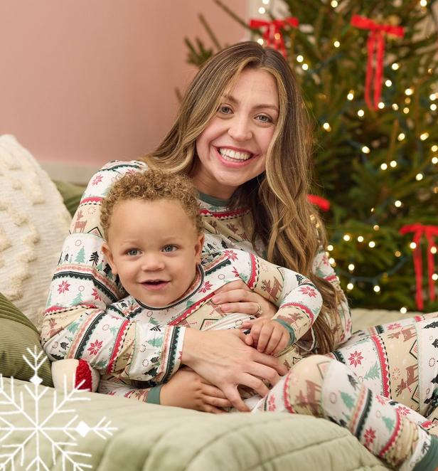 Woman and young boy wearing matching red white and green Christmas pajamas.