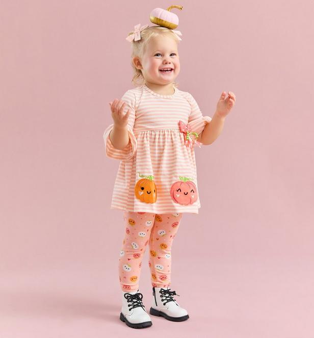 Little girl wearing a peach pumpkin themed top and pants