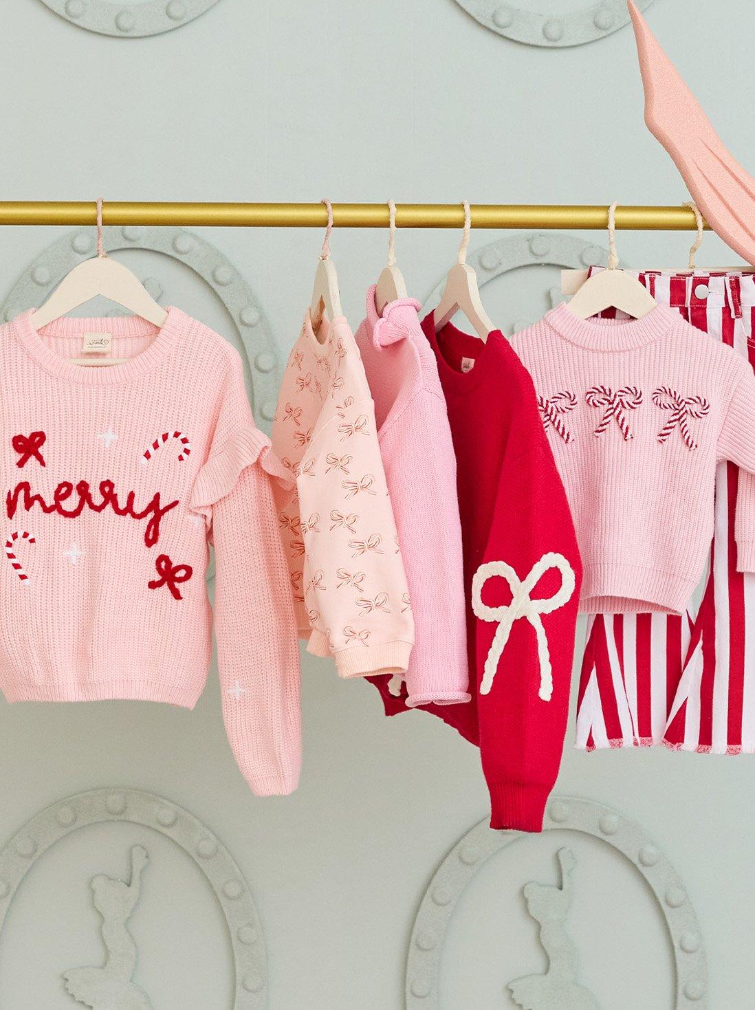 Hanging pink and red christmas themed sweaters