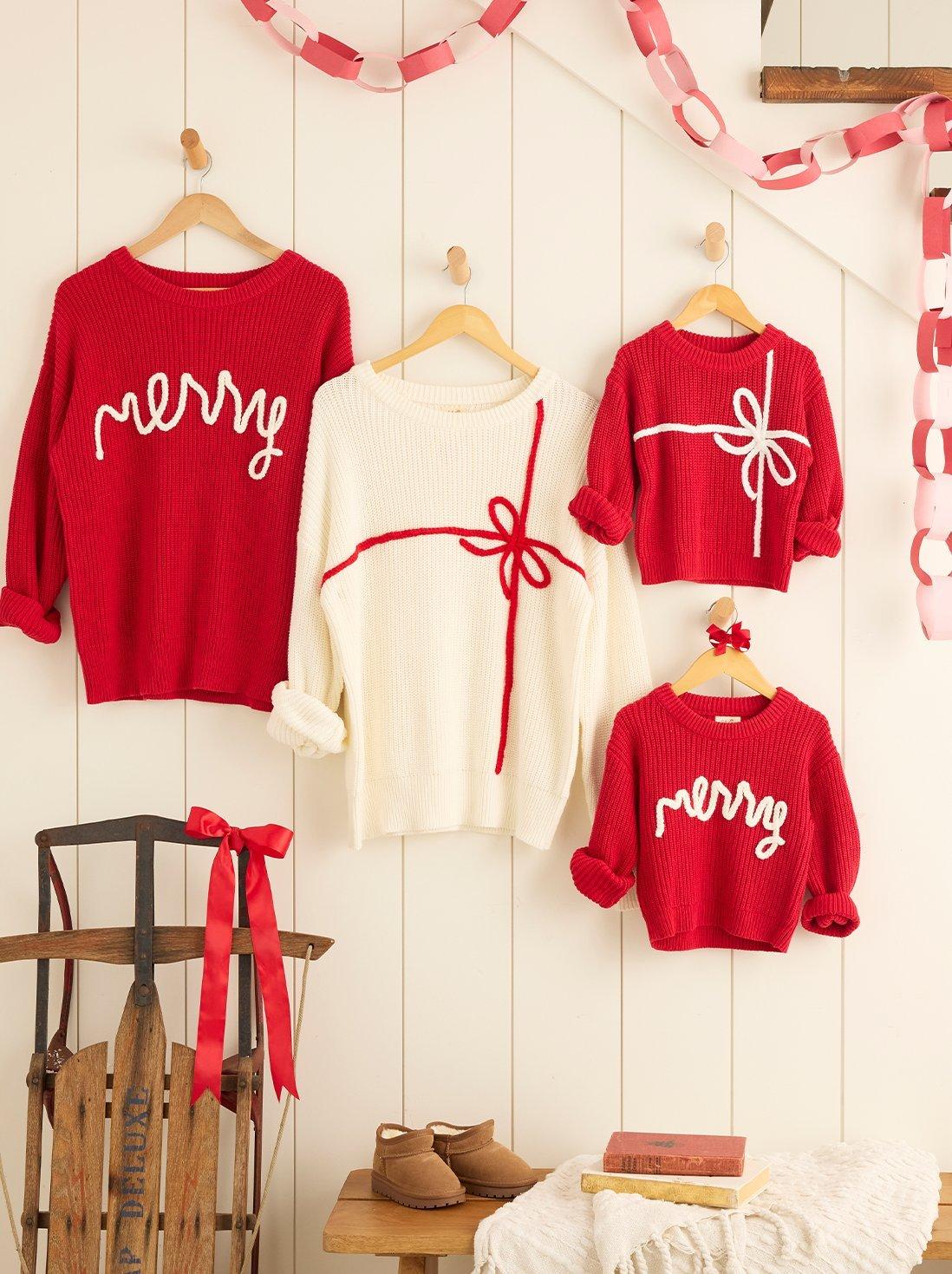 Matching red and white christmas sweaters hanging on a staircase.