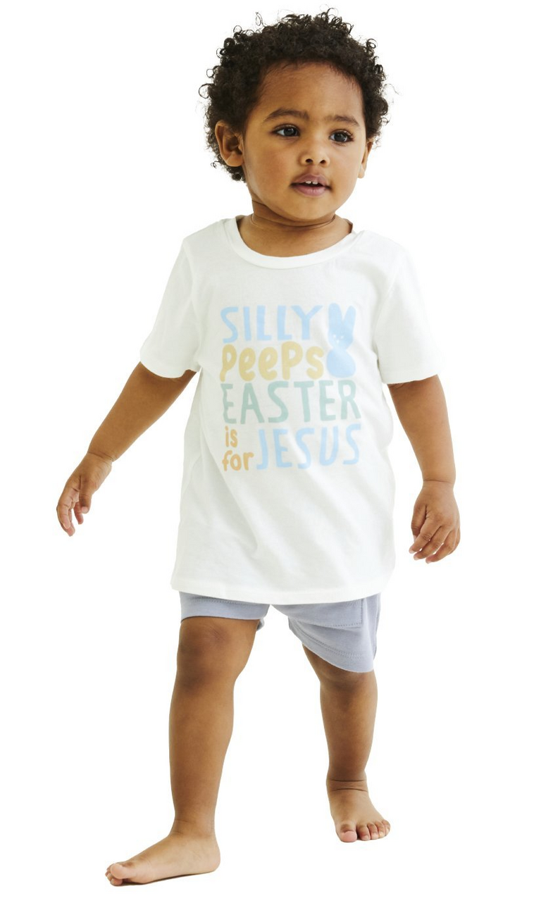toddler boy wearing a white graphic t-shirt and light blue shorts