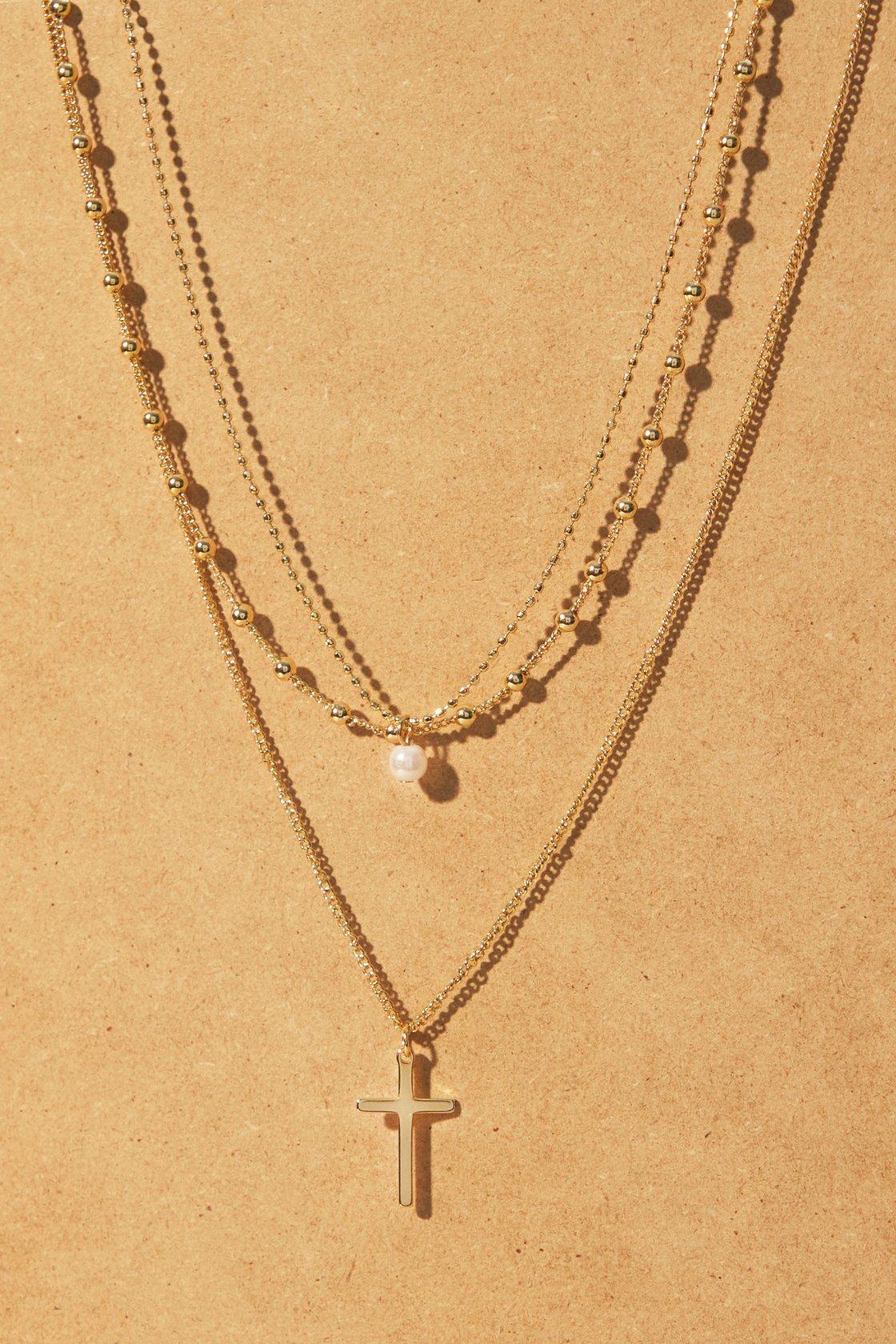 three gold-colored stack necklaces