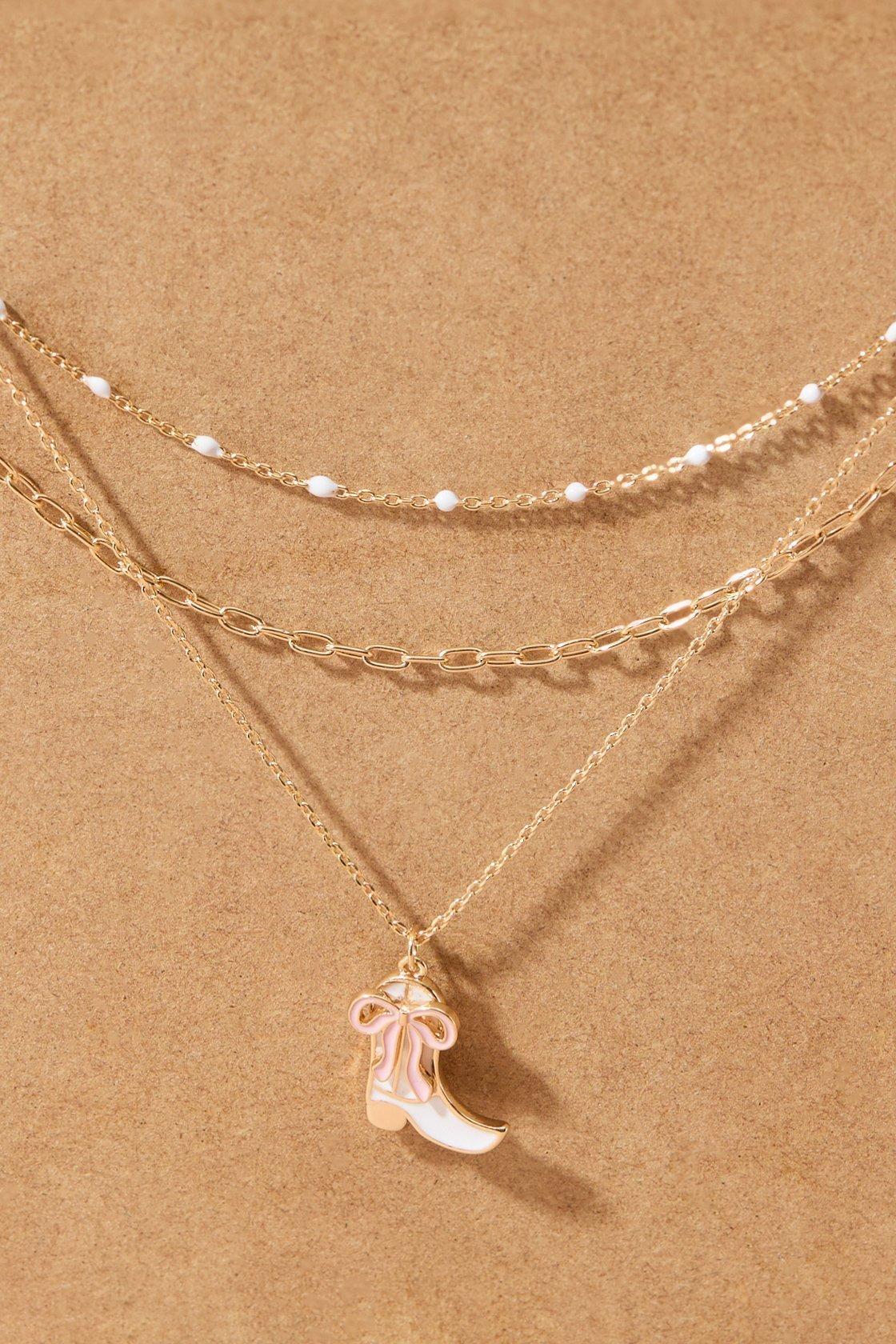 layered gold necklace with a cowboy boot charm