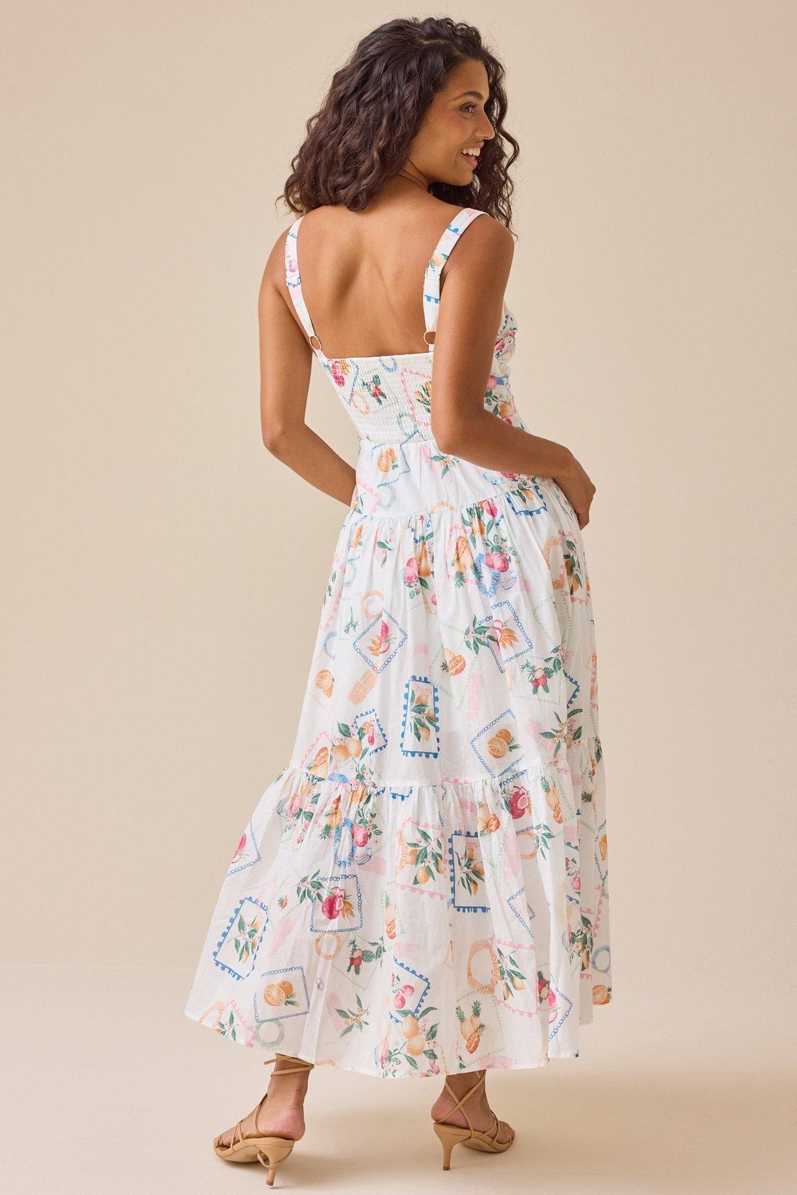 Girl wearing a white maxi dress with multi-colored summer pattern