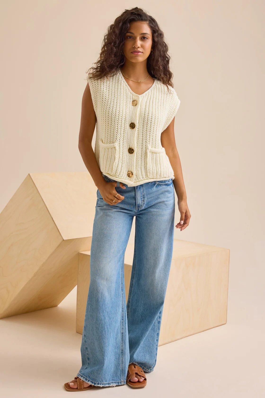 Girl wearing a cream cardigan sweater vest