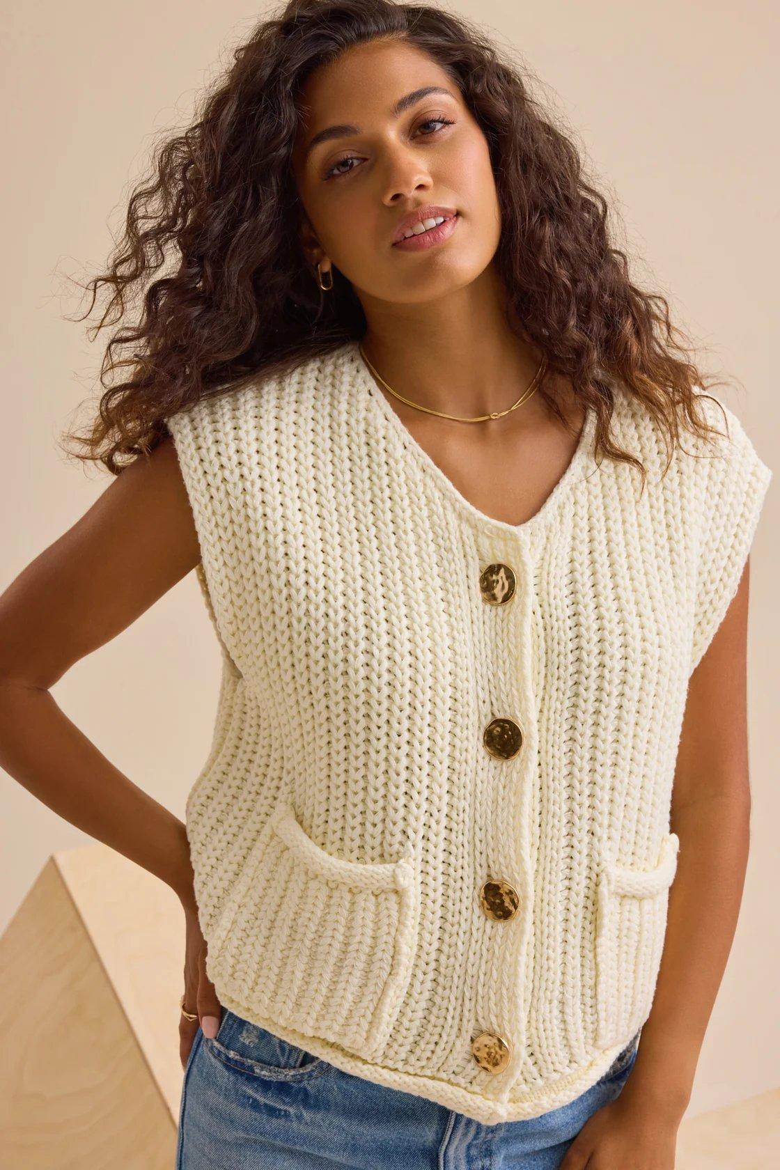 girl wearing a cream cardigan sweater vest