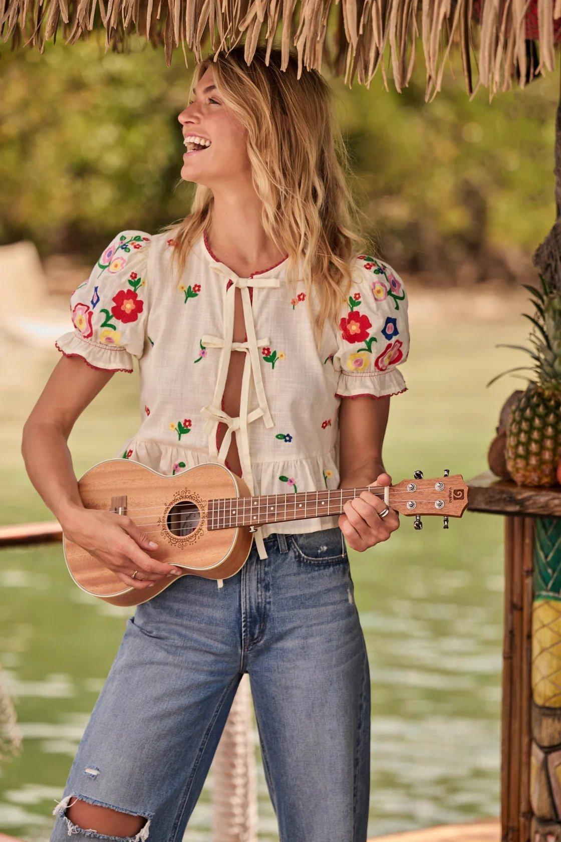 girl wearing a white tie-front top with a mult-colored embroidery