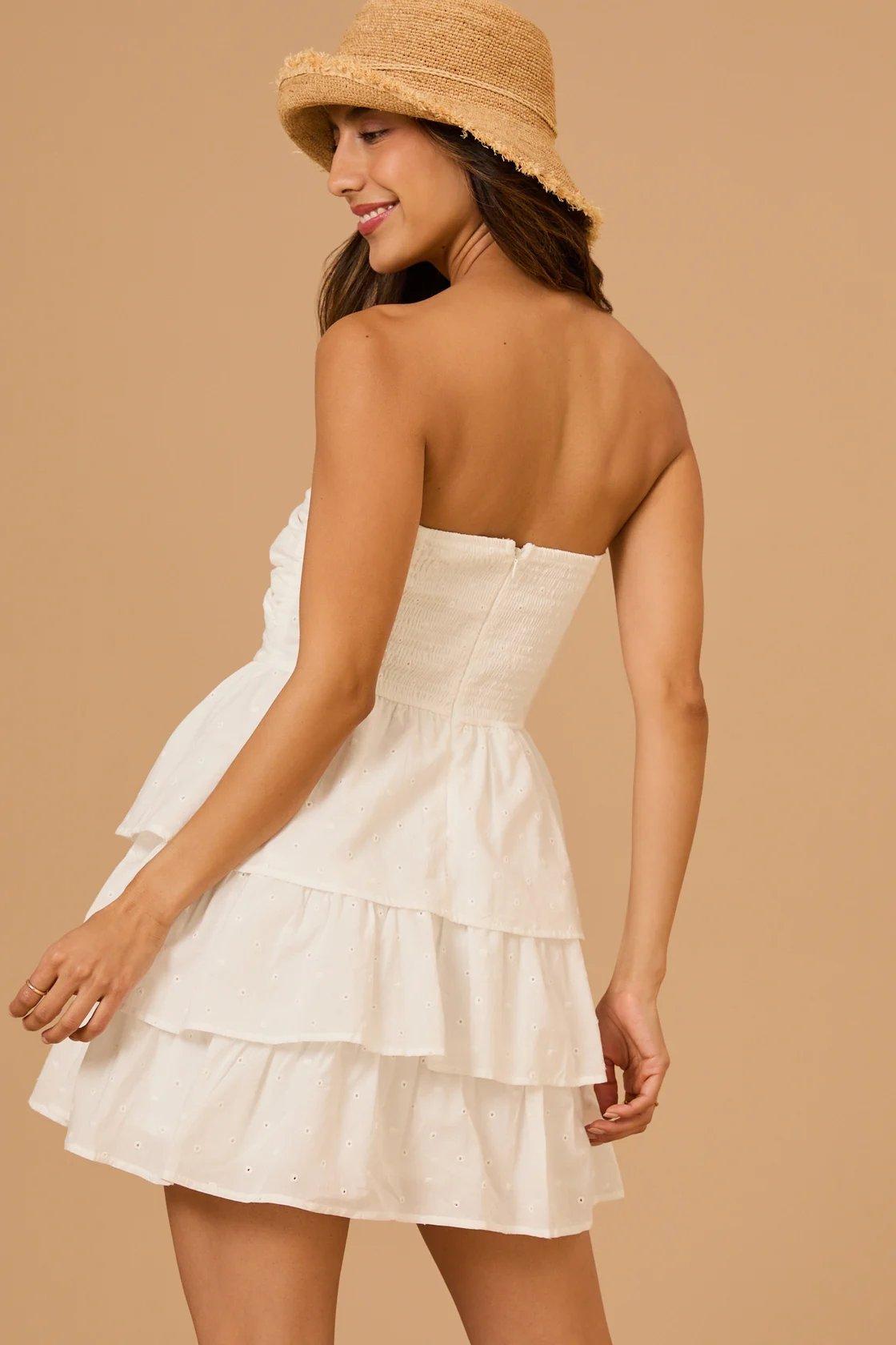 Girl wearing a strapless white tiered mini dress