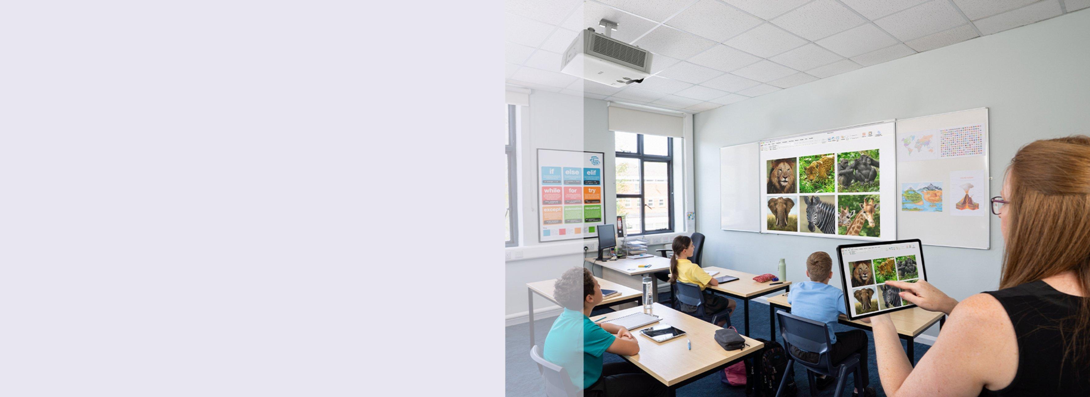Students sit at desks in a classroom watching a nature slideshow on a screen.