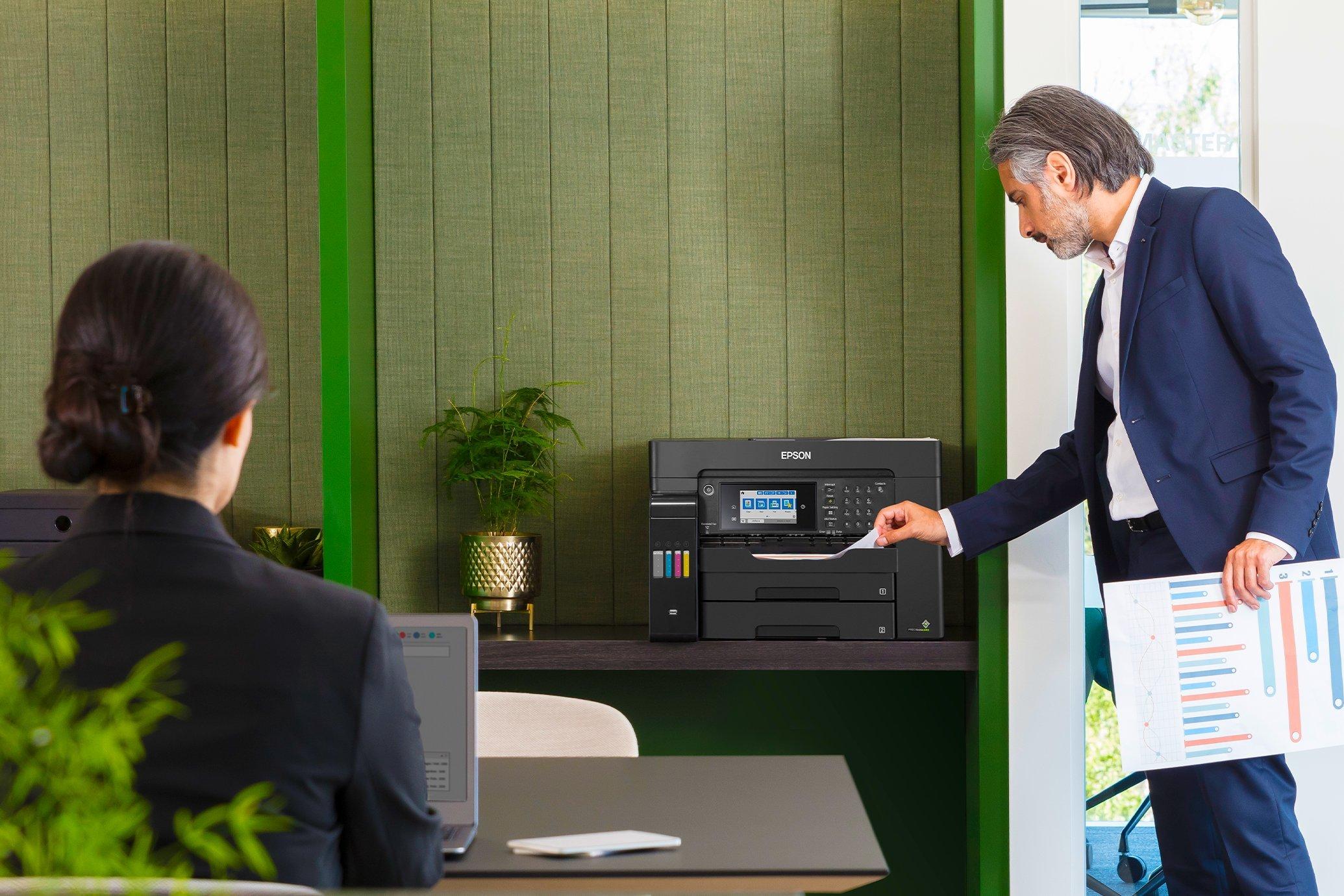 A man using a business EcoTank model on a desk in a small office