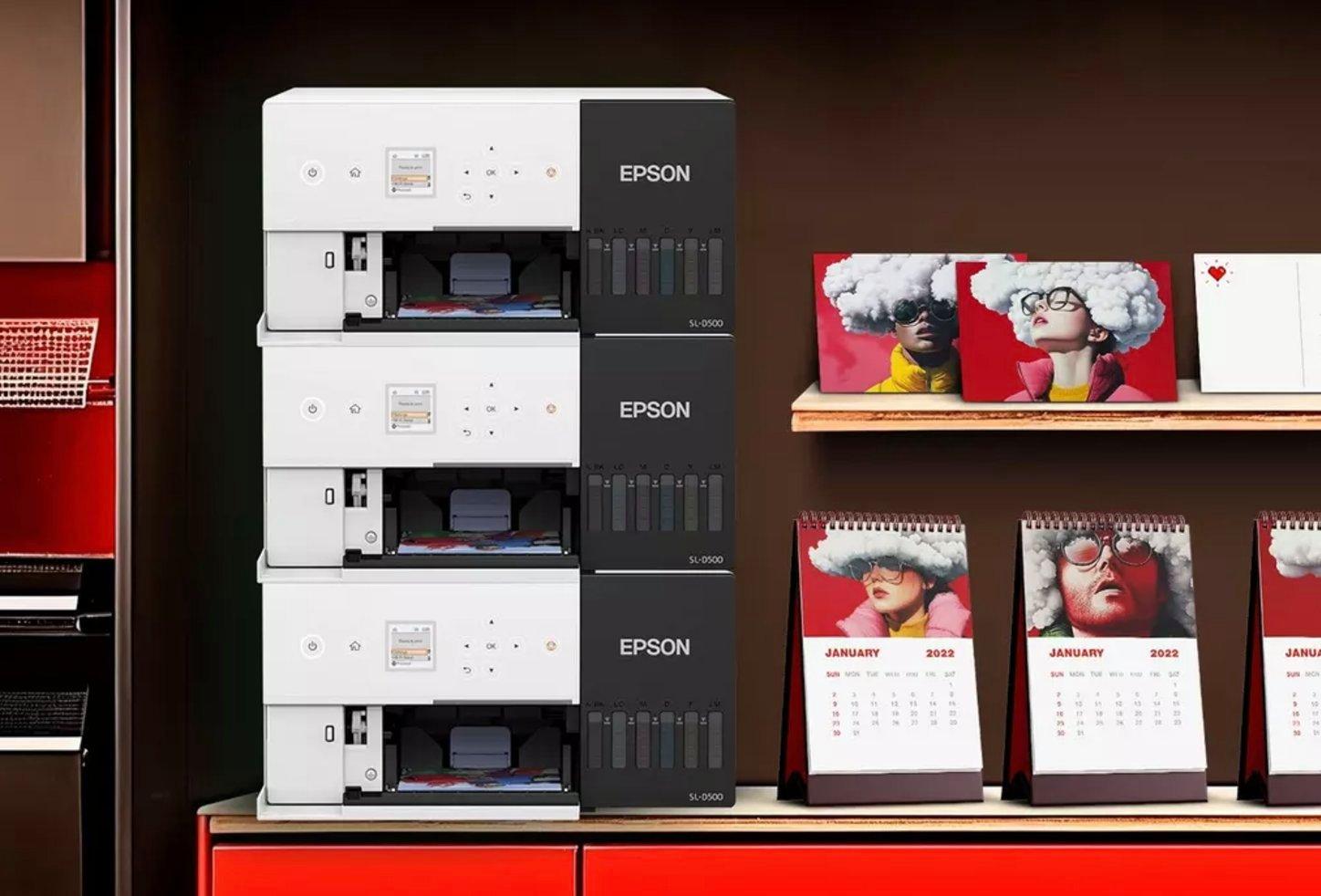Stacked Epson printers and inks on the side, logo for reddot design awards winner 2023