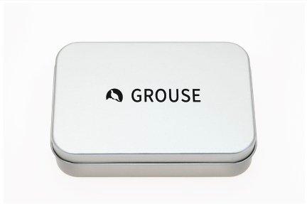A sleek, silver tin box with rounded edges featuring a black logo of a bird silhouette.