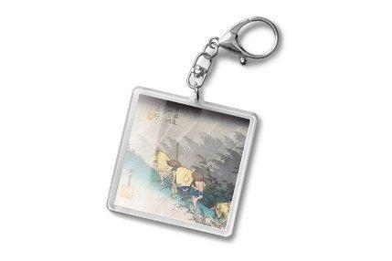 A square keychain featuring a vintage-style illustration of travellers on a misty path
