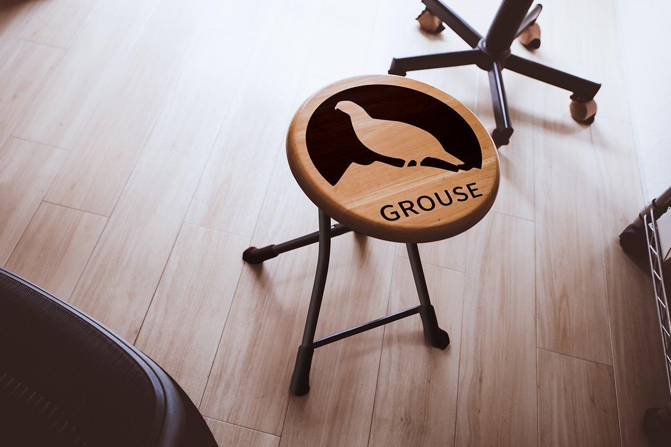 A wooden stool with a silhouette of a grouse and the word "GROUSE" on its seat.