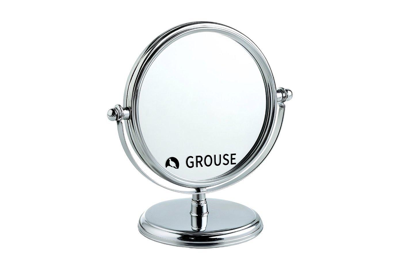 A sleek, round tabletop mirror with a chrome metal frame and stand. 