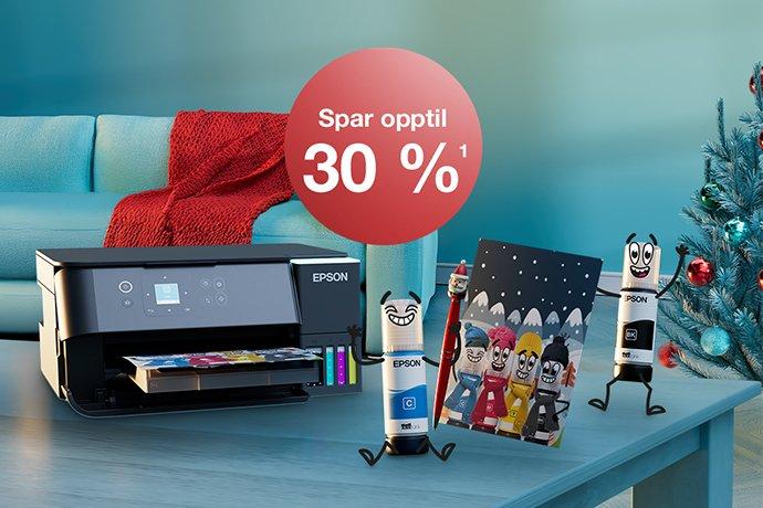 An Epson printer with Inkies and a Christmas card on a blue table with a Christmas tree in the back