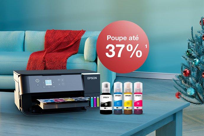 An Epson printer with ink bottles on a blue table with a Christmas tree in the back