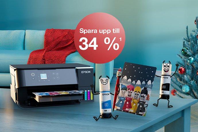 An Epson printer with Inkies and a Christmas card on a blue table with a Christmas tree in the back