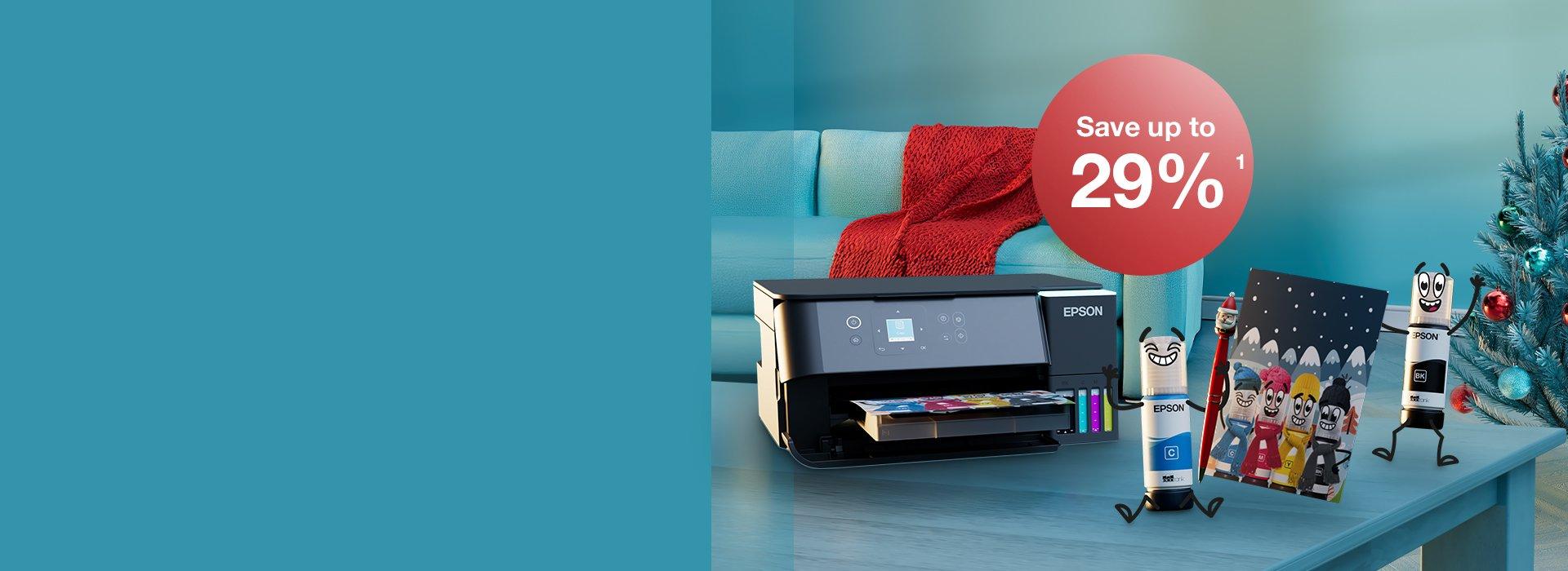An Epson printer with Inkies and a Christmas card on a blue table with a Christmas tree in the back