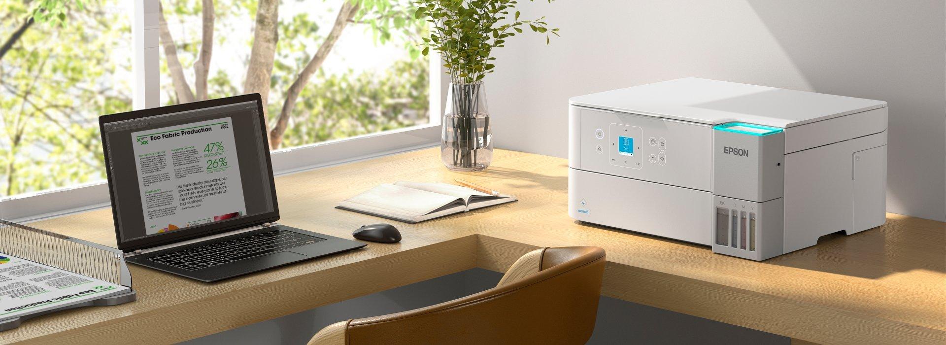 A modern home office features a laptop, a sleek white Epson printer, and a decorative vase on a corner desk by a bright window.
