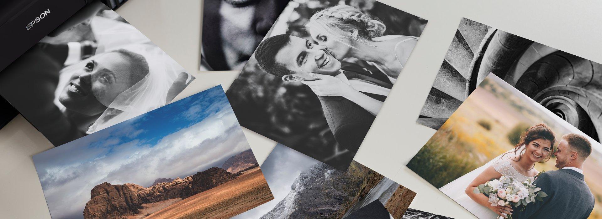 Various printed photographs scattered haphazardly on a table. Some are black and white photos from a wedding, others colourful landscape shots.