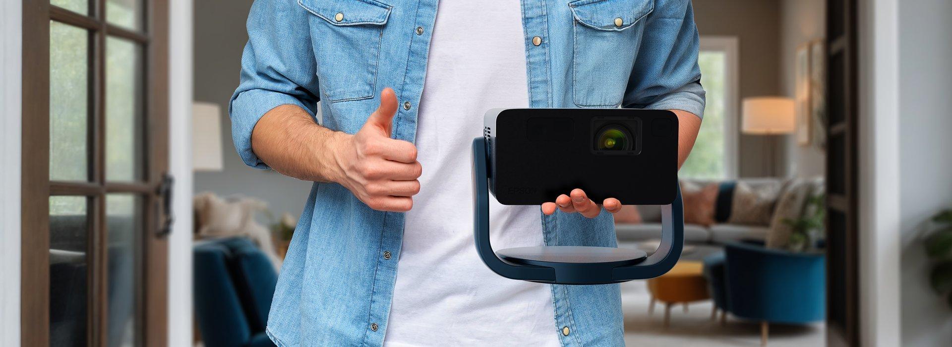 Man carrying a portable Epson projector in one hand.