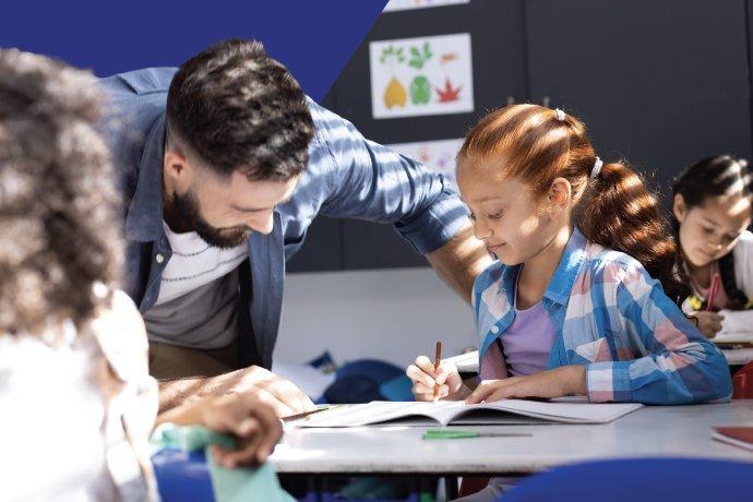 Teacher supporting a child with their work in class.