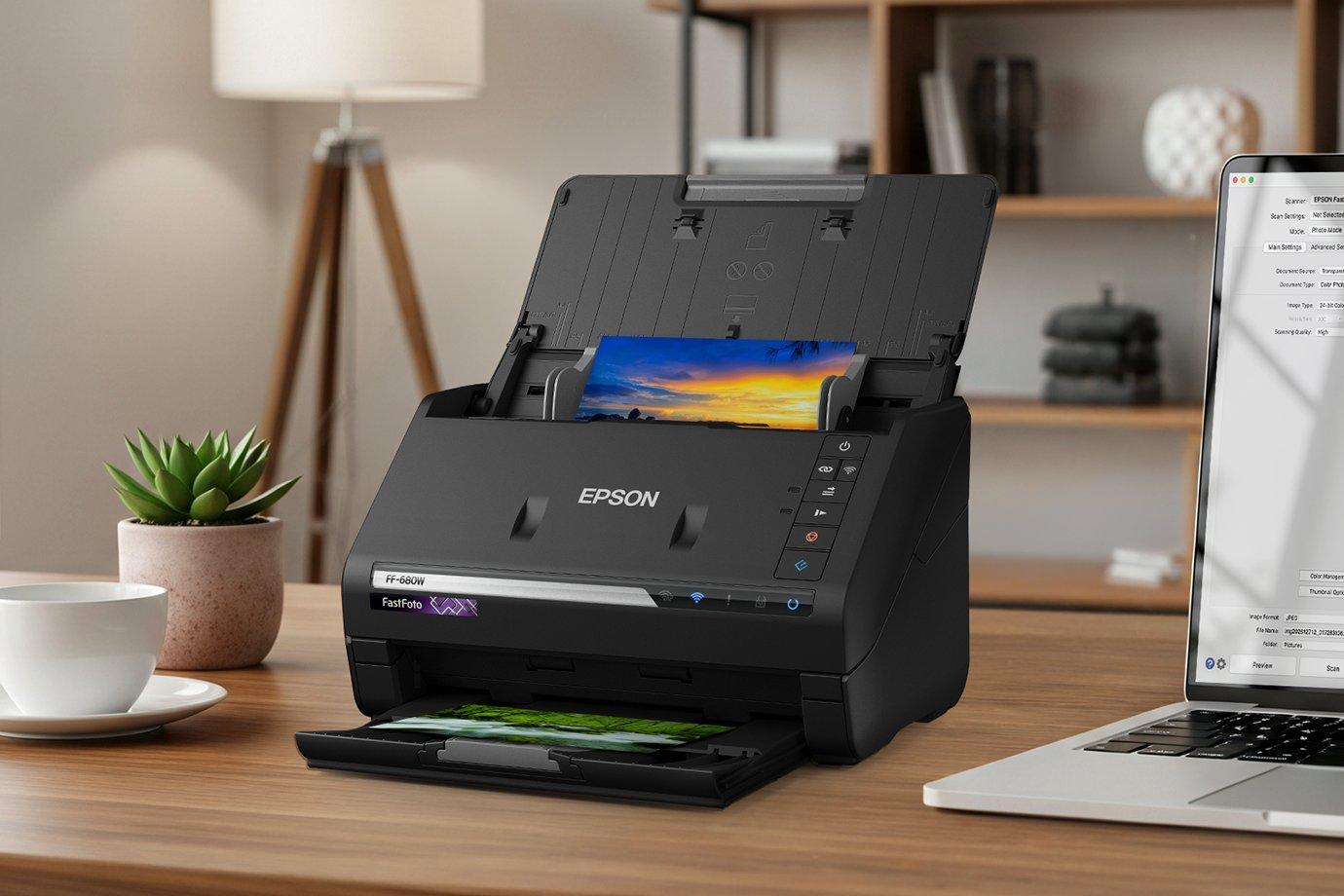 A black Epson scanner on a wooden desk processes a vibrant photo. 