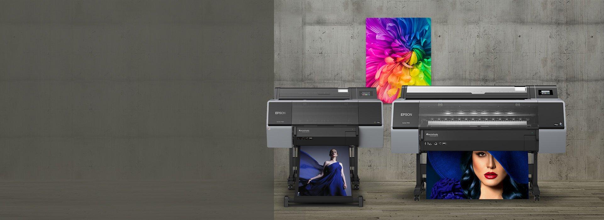 Two printers with prints of a lady in blue against a grey wall in the background with a colour print