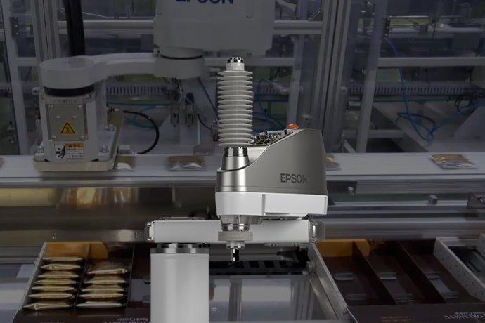 Industrial robotic arm labeled "Epson" working in a factory setting, surrounded by conveyor belts carrying packaged goods.