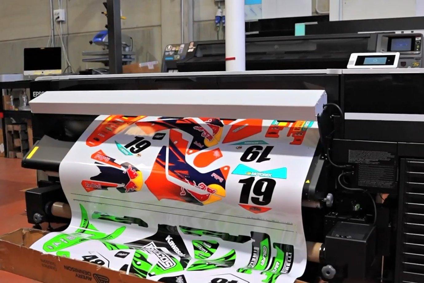 Large-format printer producing colorful motorsport graphics.