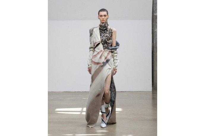 Três pessoas a desfilar com vestidos da moda estampados com tinta.