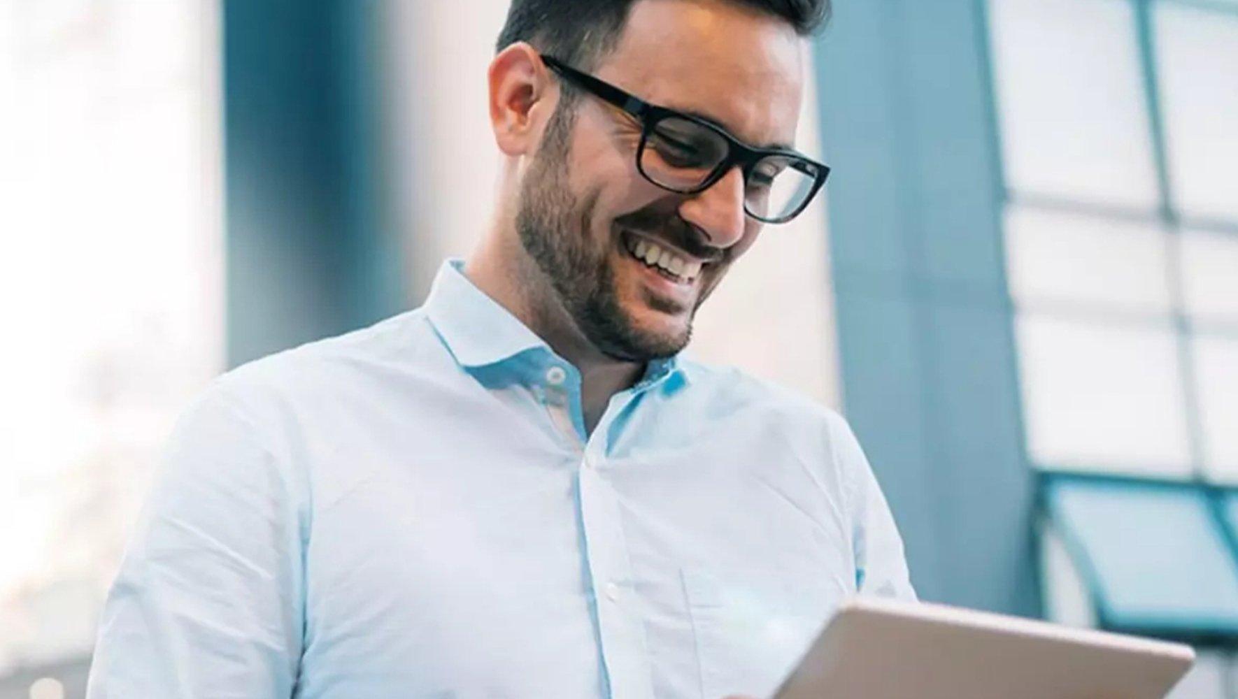 A man smilling at tablet