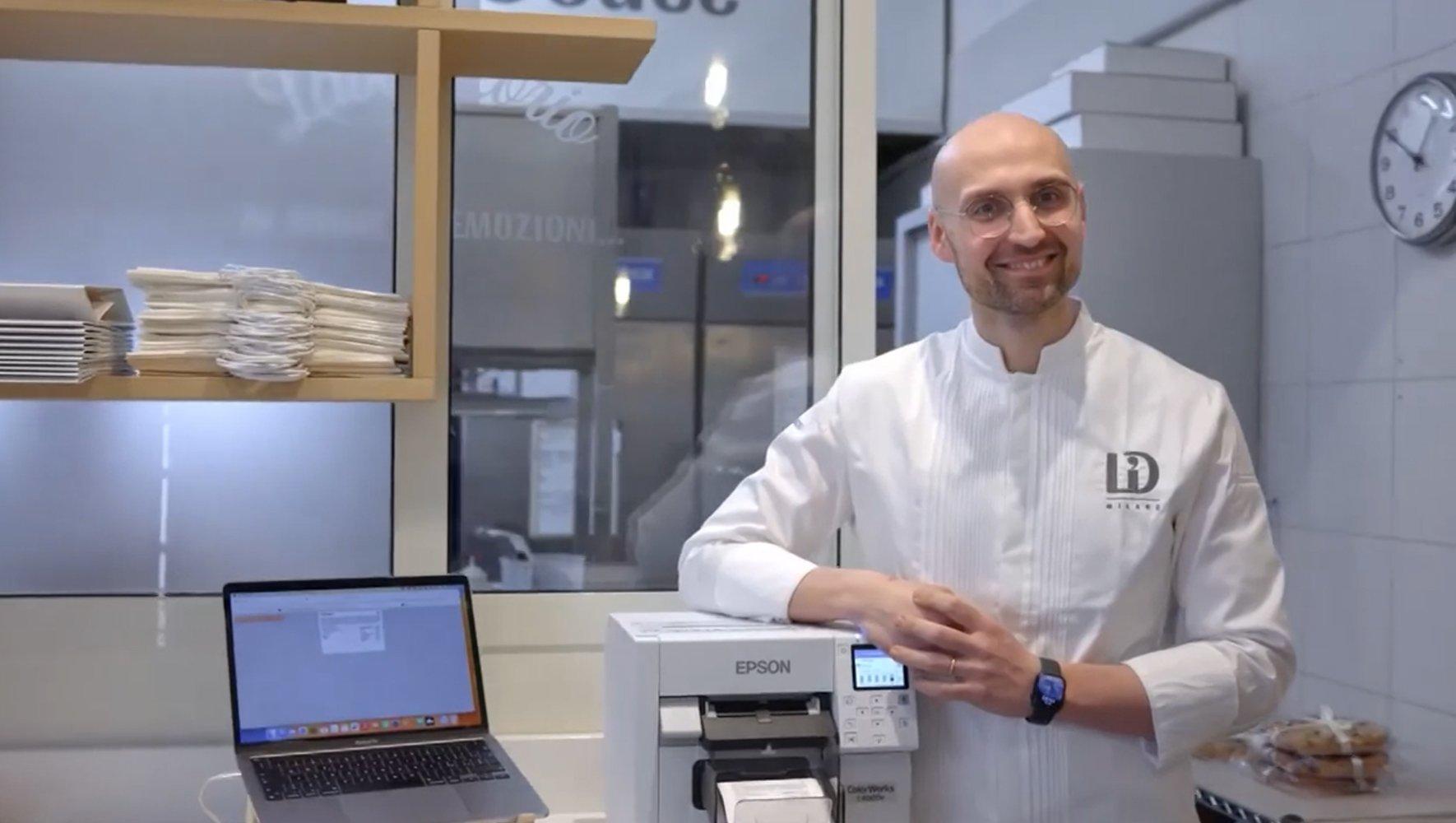 A man smilling next to a printer