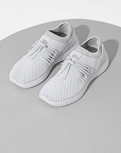 A pair of white sneakers on a light grey background.