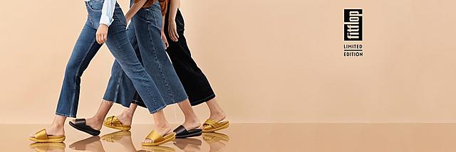 Three pairs of Loosh Lux Sandals shown in Gold and Black and classic and cross-over slides options. 