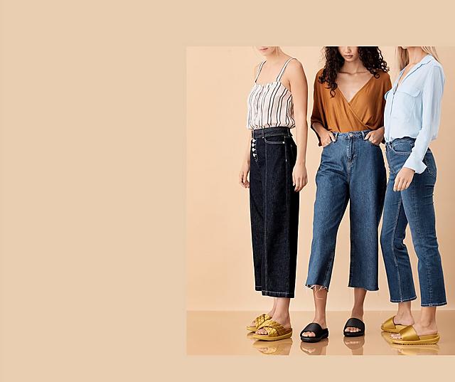 Three models wearing Loosh Lux Sandals shown in Gold and Black and classic and cross-over slides options. 