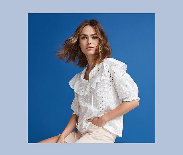 A woman wearing a white blouse on a blue background.