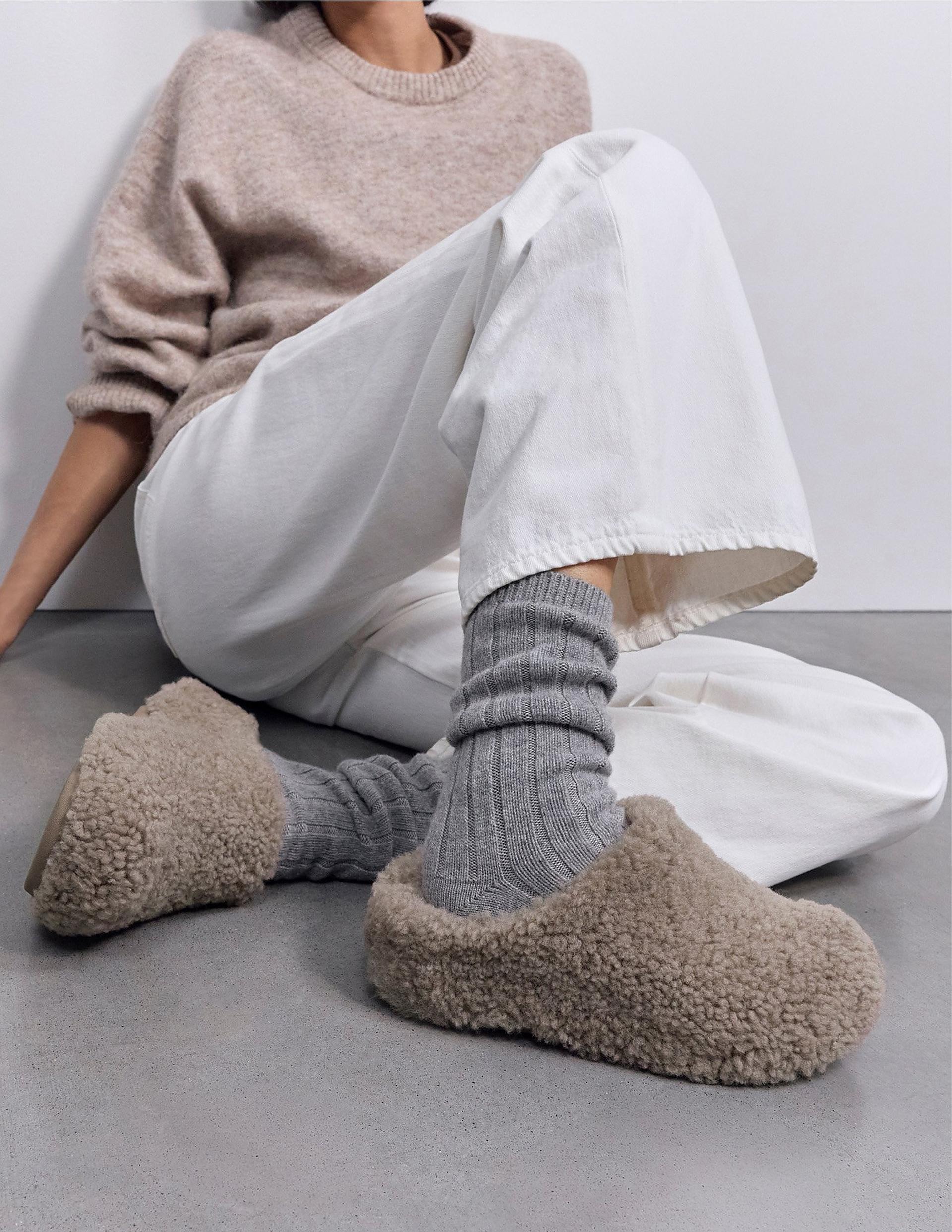 Model wearing clog shearling slippers