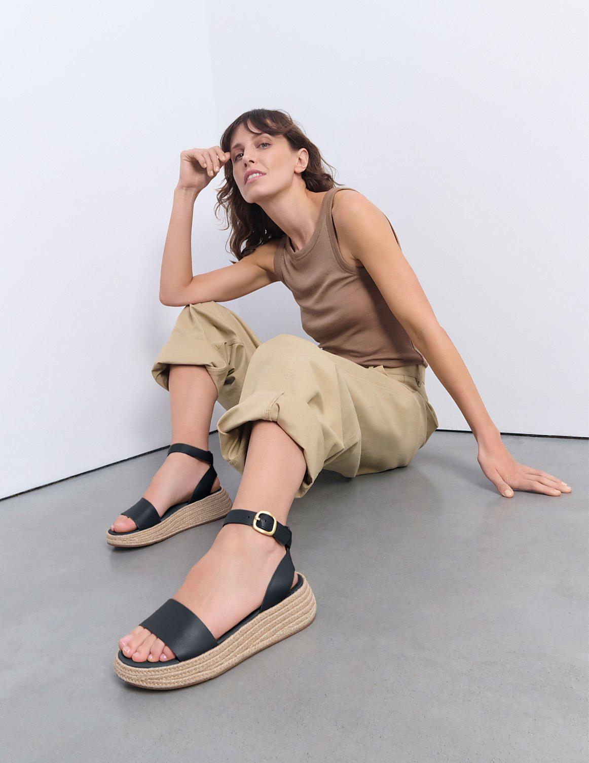 Woman wearing black leather flatform sandals