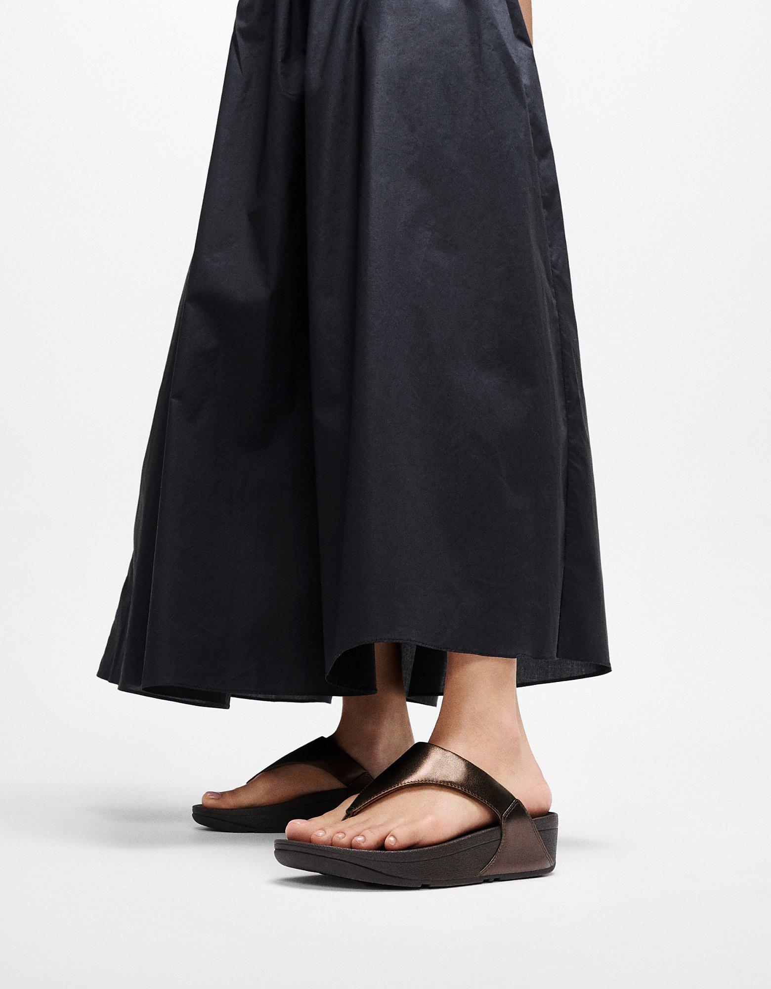 Woman wearing black skirt and F MODE fisherman sandals - From FitFlop US
