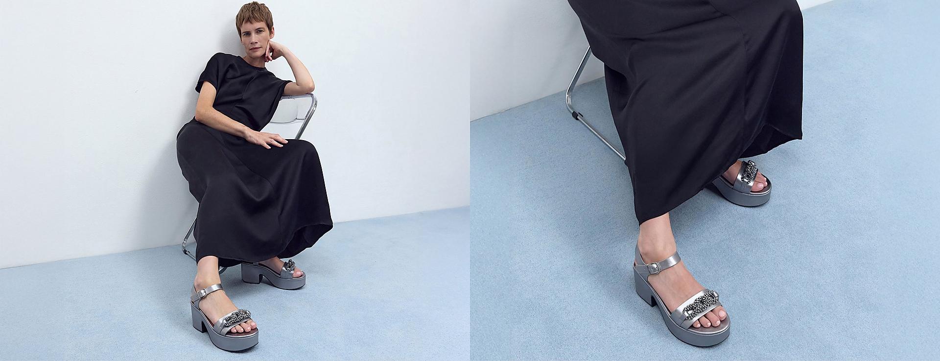 A female model styling and wearing platform sandals in a metallic colour with jewels.