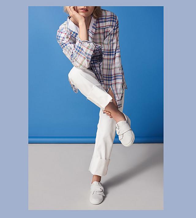 Model shot of Bowy Leather Slip-on Sneakers in white matched with white pants and a plaid shirt.